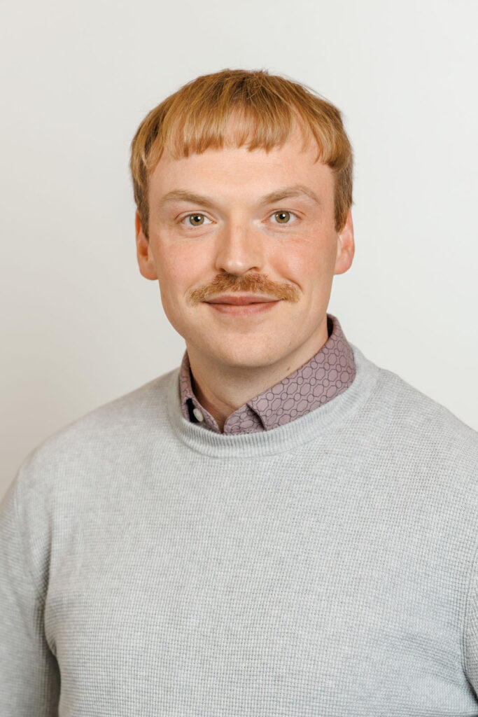 Portrait of a smiling man with a mustache.