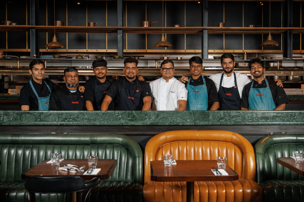 Restaurant staff smiling behind counter.