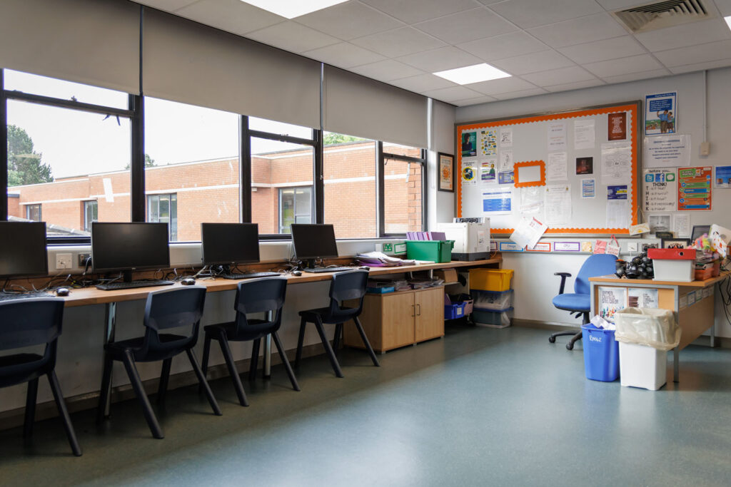 School computer lab with multiple workstations and teacher's area.