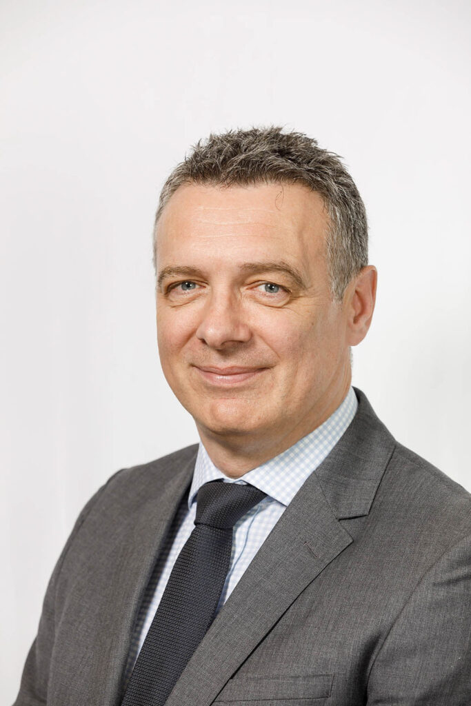Smiling businessman in a suit, headshot.