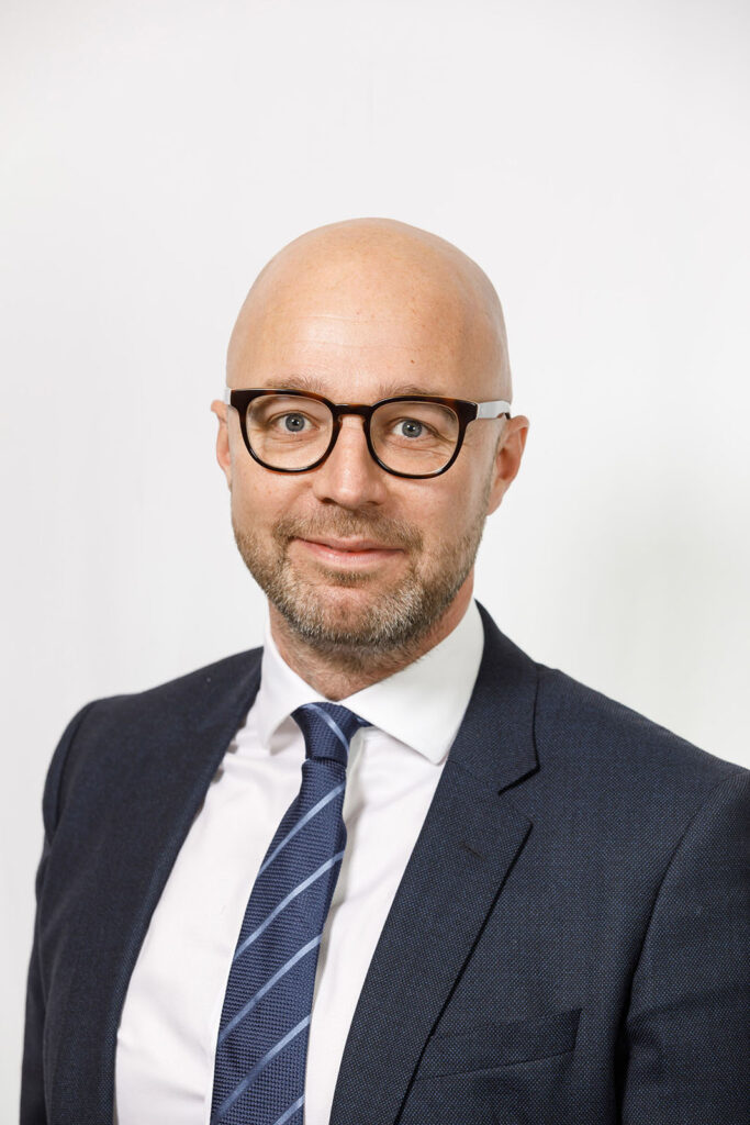 Smiling businessman in glasses and suit.
