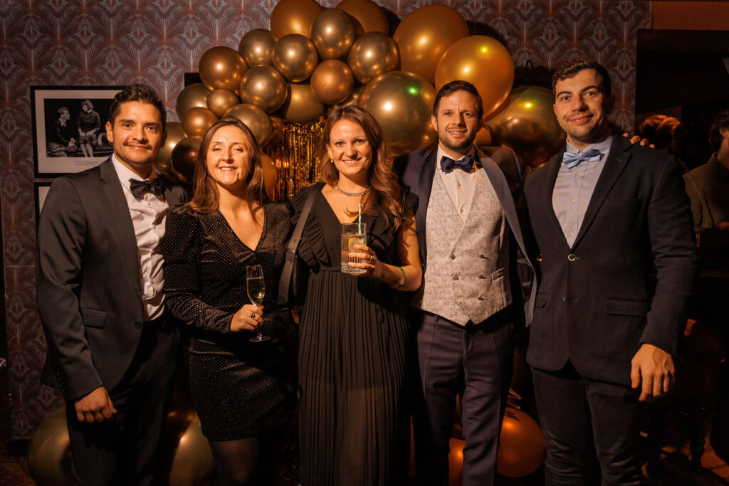 Smiling friends in formal wear at a festive gathering.