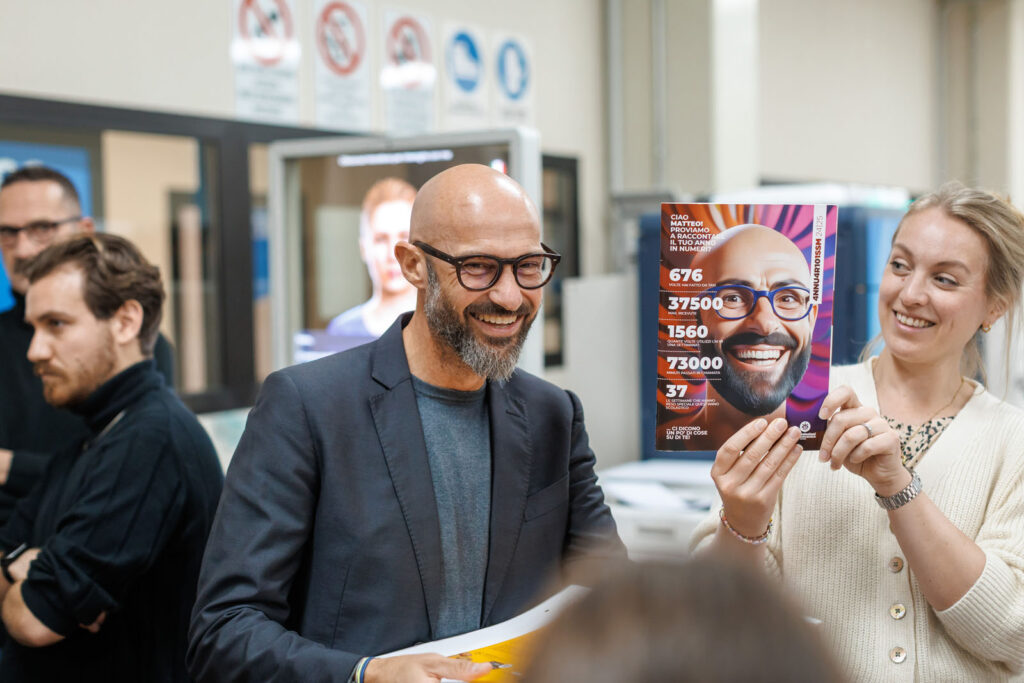 Smiling man and woman presenting a personalized magazine cover.