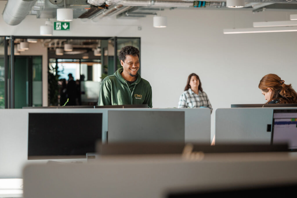 Smiling man in modern office with colleagues.