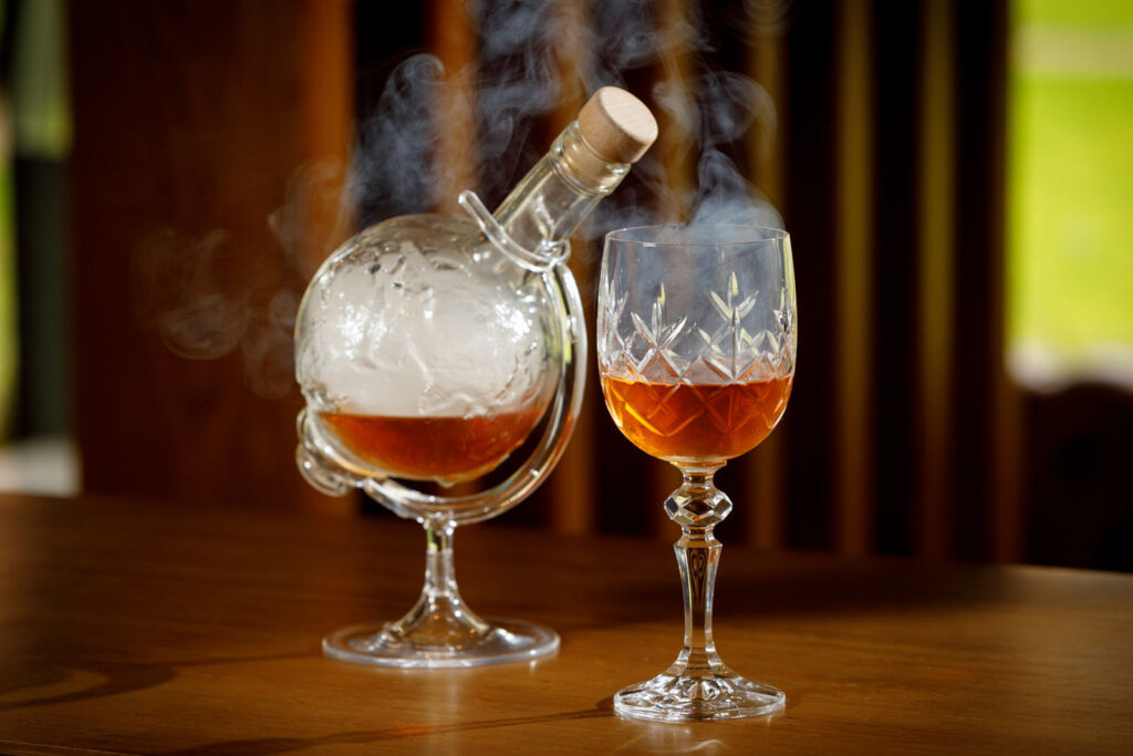 Smoked whiskey in a globe decanter and crystal glass.