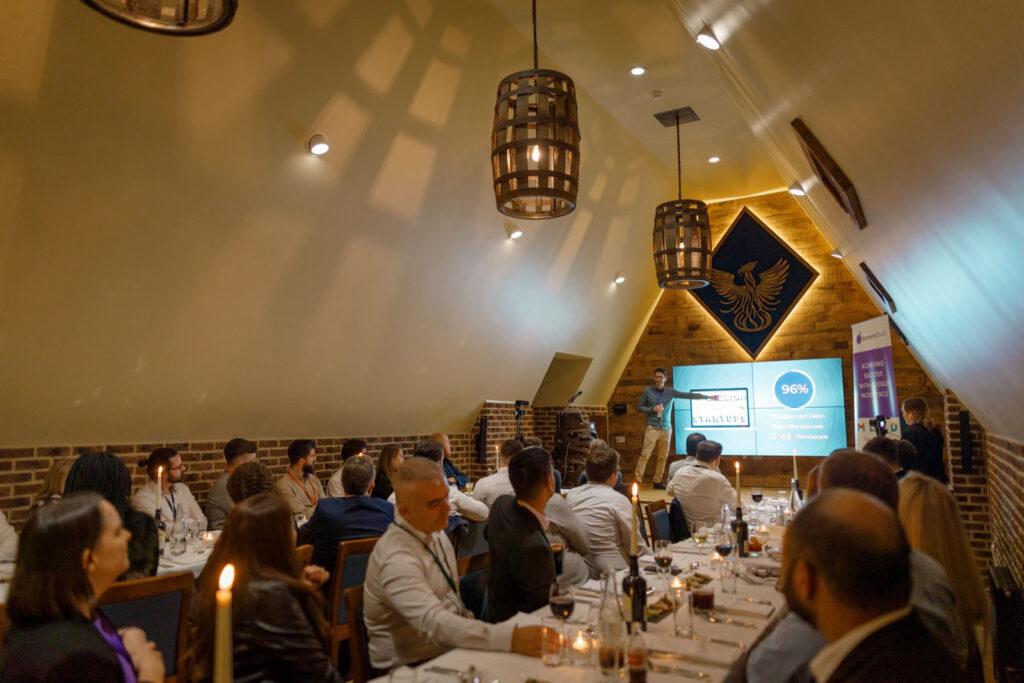 Speaker addresses audience at a formal business dinner.