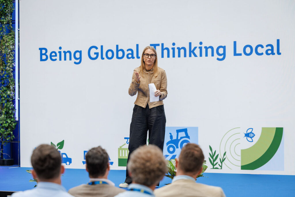 Speaker discusses being global, thinking local with audience.