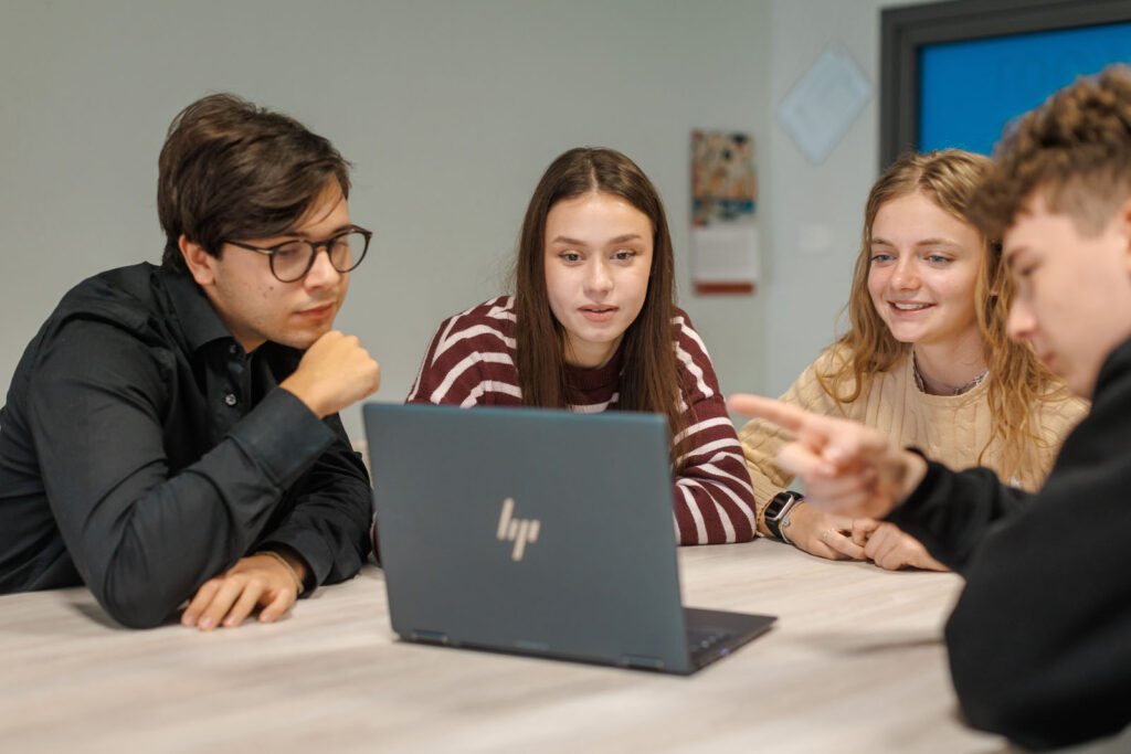 Students collaborating on a laptop.