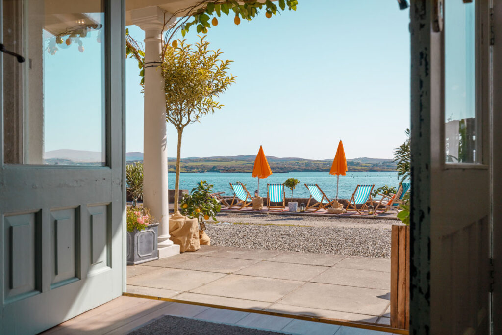 Sunny patio with lake view, deck chairs, and lemon trees.