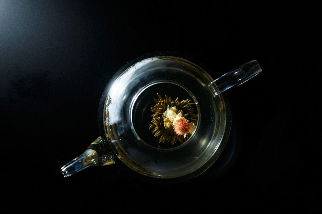 Tea flower blooming in glass teapot.