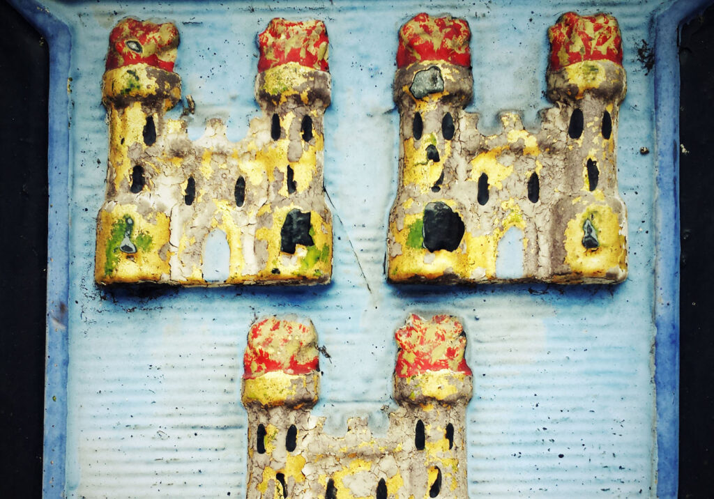 Three colorful, weathered castle reliefs.