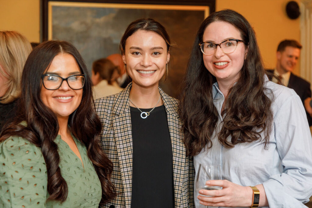 Three smiling women at an event.