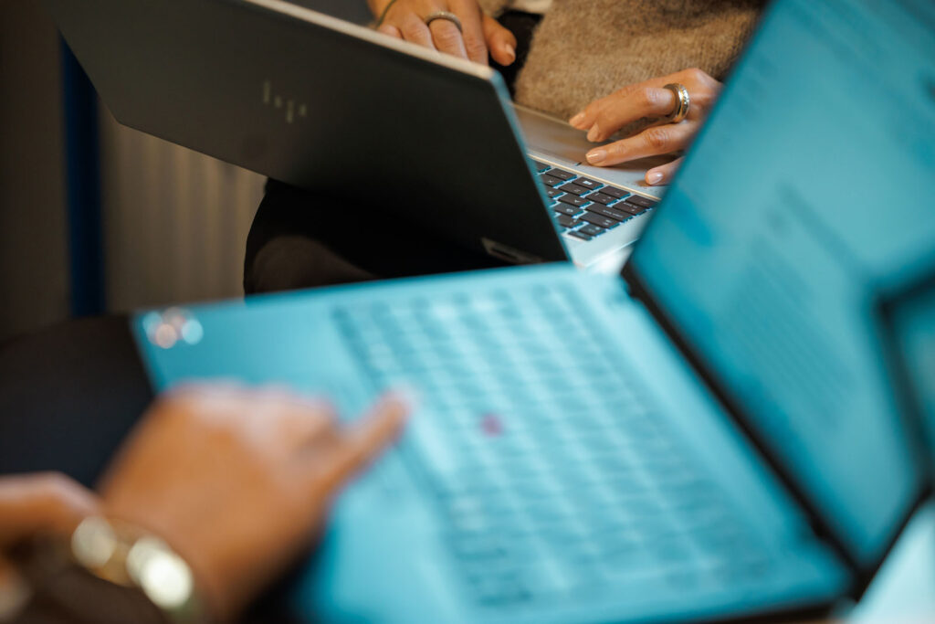 Two people collaborating on laptops.