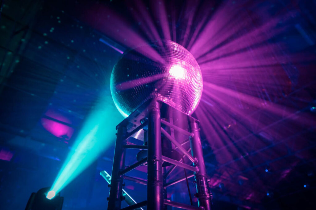Vibrant disco ball reflecting purple and blue light.