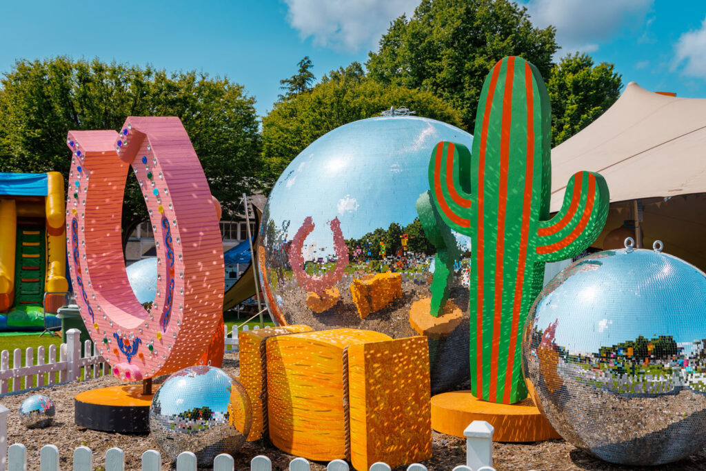 Whimsical outdoor decorations: disco balls, cactus, and horseshoe.