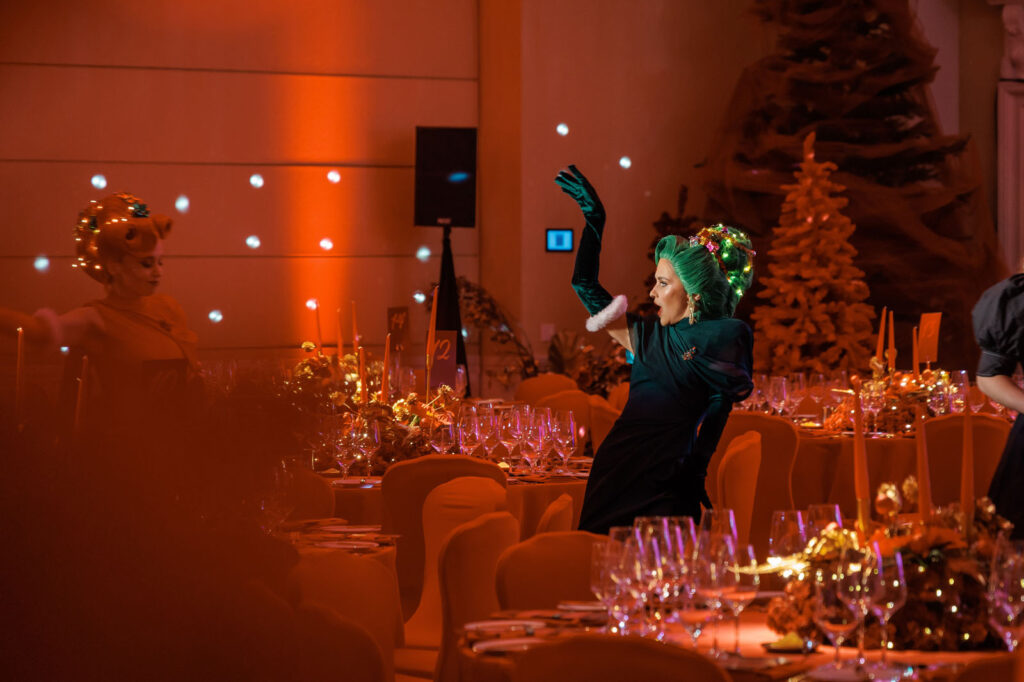 Woman in green hair and festive attire at a holiday event.