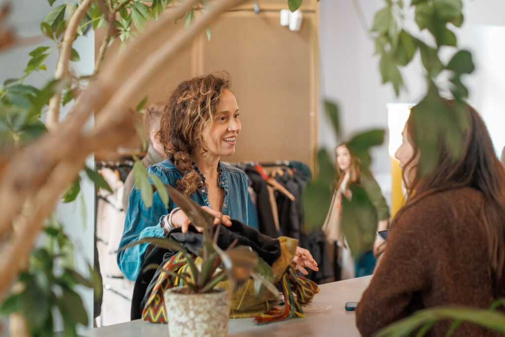 Woman smiling while shopping for clothes in a boutique.