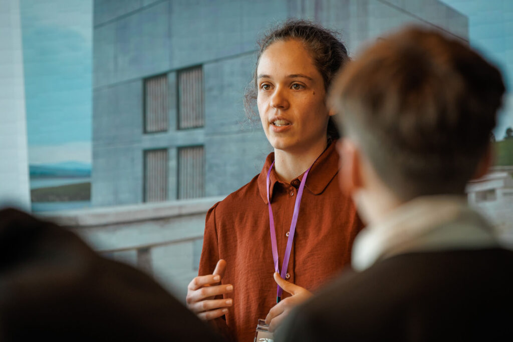 Woman with lanyard speaking at a presentation.