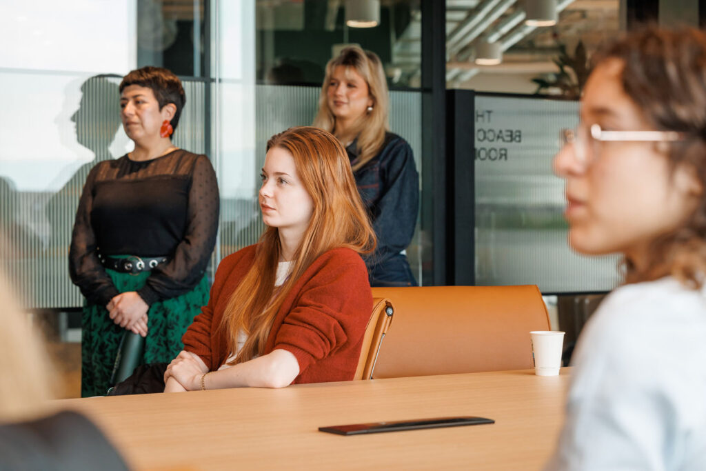 Women listening in a modern office meeting.