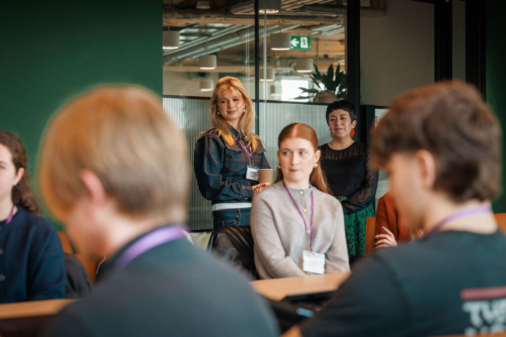 Women presenting to a group in a modern office.